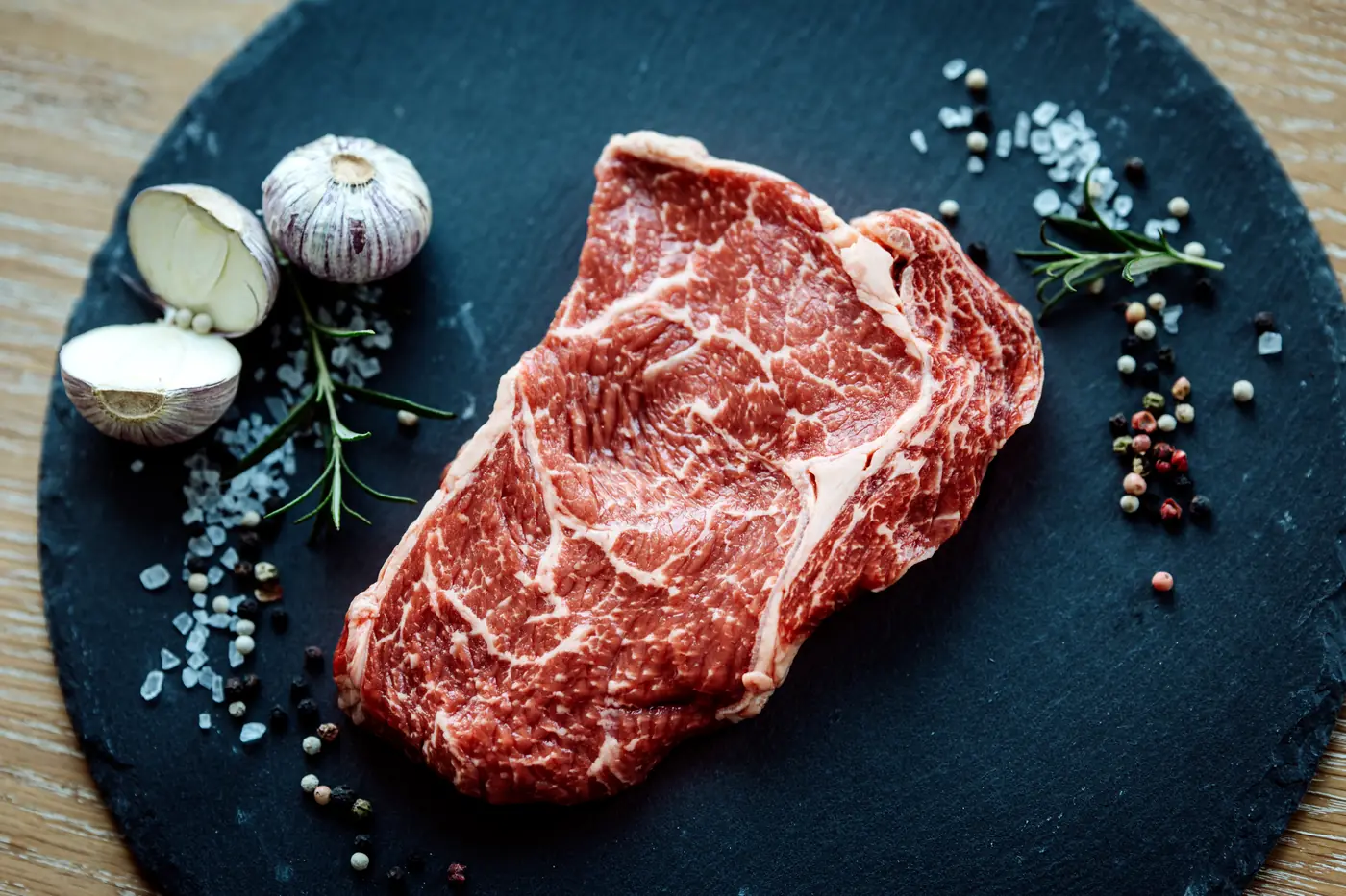 Rumpsteak vom Galloway auf einer Schieferplatte mit Knoblauch und Pfeffer